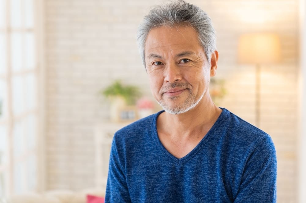 asian man with very short grey stubble 