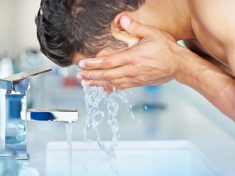 teen guy washing face