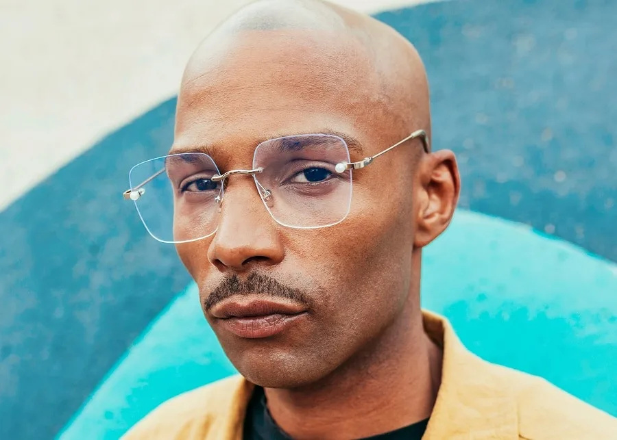 black bald guy with thin mustache
