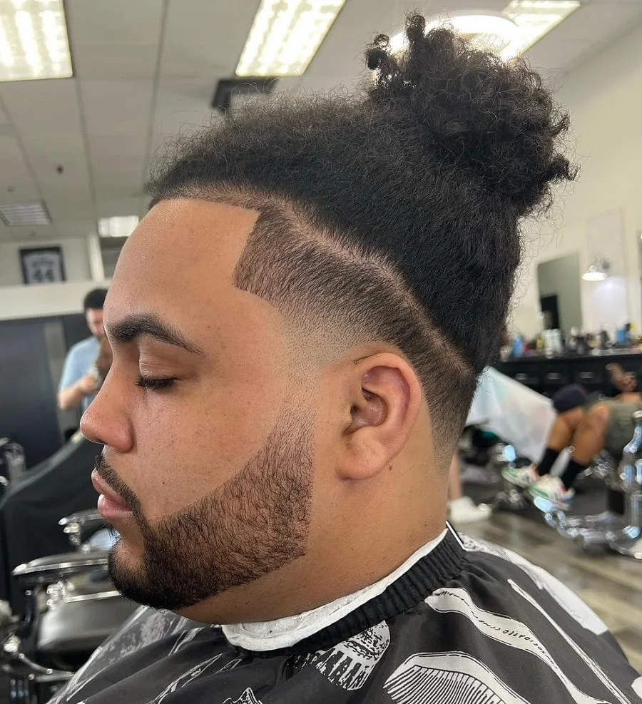 curly topknot with taper fade and beard