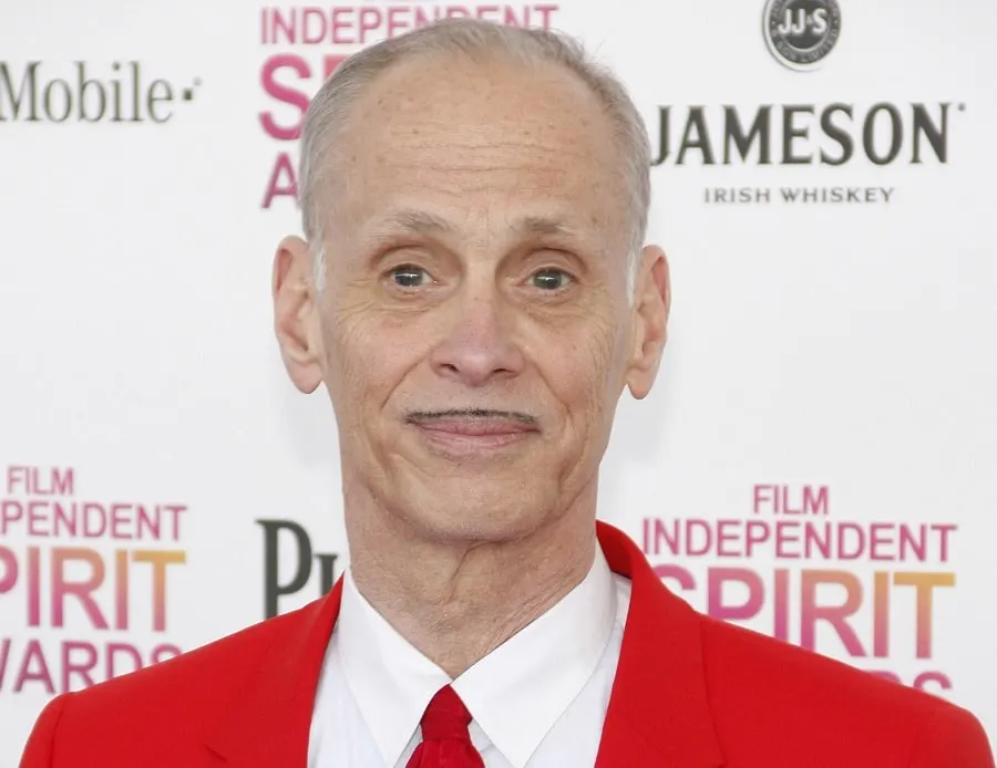 old actor John Waters with pencil mustache