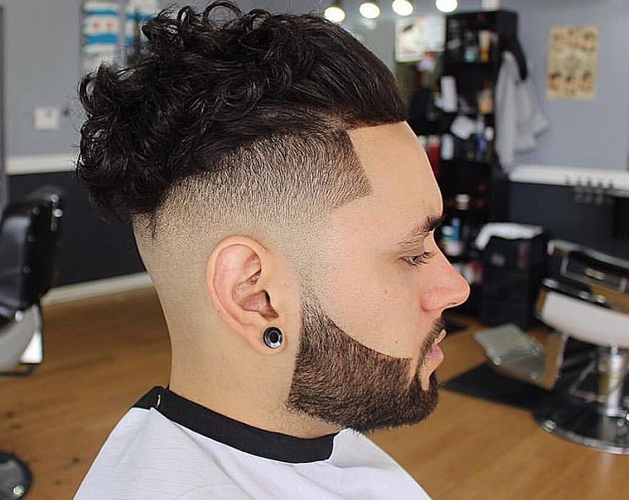 curly slicked back hairstyle with faded beard