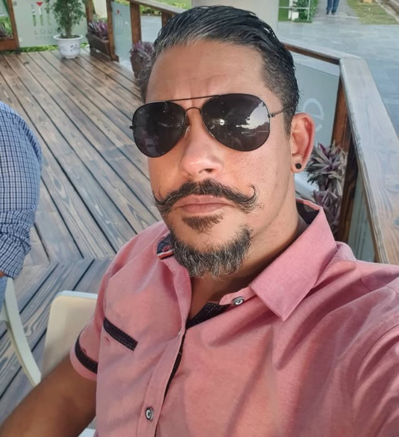 classic Van Dyke beard featuring a disconnected, curled handlebar mustache and an isolated chin patch