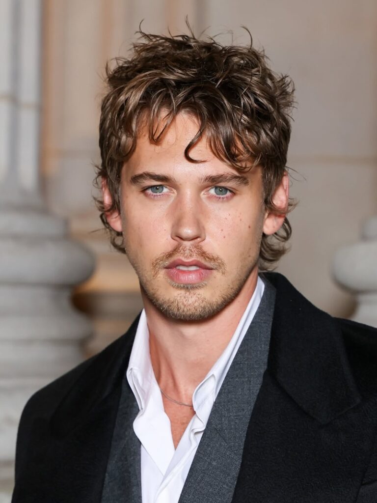 ustin Butler with a light mustache and faint stubble